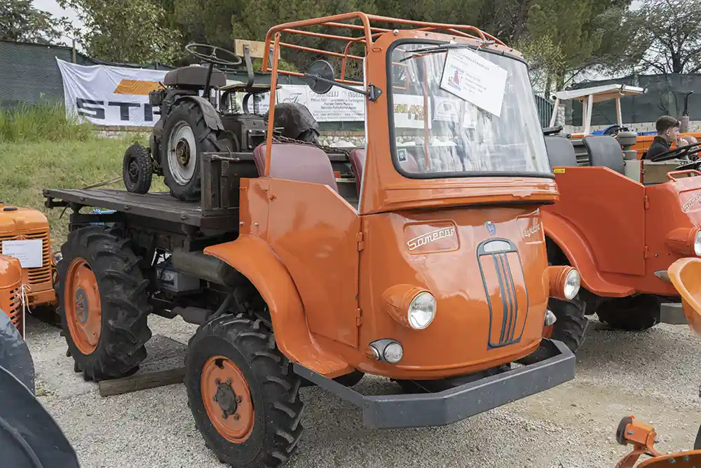 Un Samecar del 1964 che trasporta un piccolo trattore.